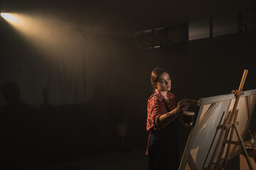 Female artist energetically drawing with paint brush, creates modern masterpiece of the oil...
