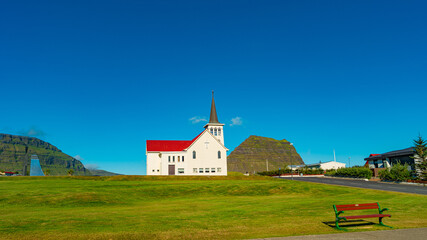 Fototapeta na wymiar Grundarfjordur, Iceland - Icelandic church in Western Iceland, at blue sky and sunny day