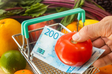 Prices of food, vegetables and fruits in Norway, Financial concept, Tomato placed in a basket with...