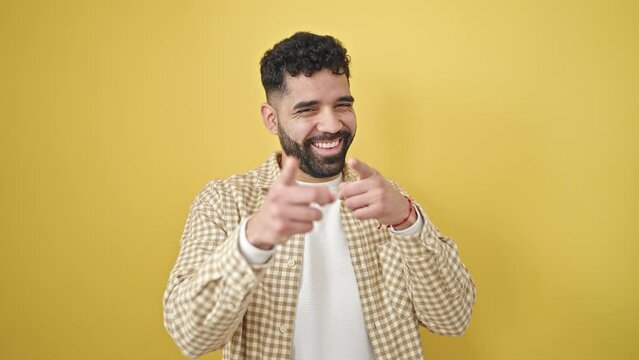 Young hispanic man smiling confident pointing with fingers to the camera over isolated yellow background
