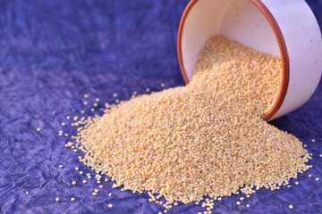 A closeup picture of a foxtail Millet grains spilled from bowl