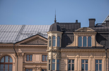 Fototapeta na wymiar Roofs and facades with tower and dorms, a sunny summer day in Stockholm