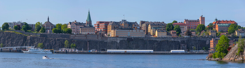 The ridge Stigberget in the district Södermalm with old 1800s houses and churches and the pier Stadsgården, a sunny summer day in Stockholm