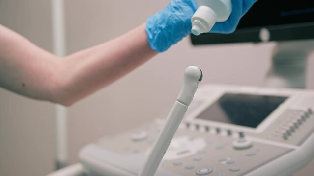 Gynecologist applies gel on transvaginal ultrasound to diagnose patient in clinic medicine and health concept close-up gel on devices