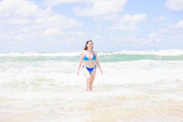 Fototapeta na wymiar 海につかる水着姿の白人女性