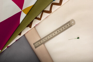Tailor's ruler against the background of fabric cuts. View from above