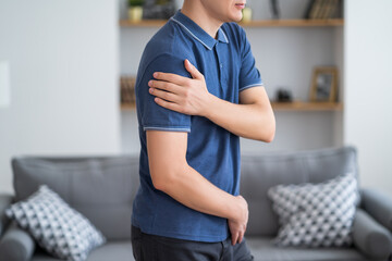 Man with pain in shoulder at home