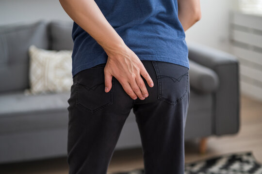 Hemorrhoidal pain, man suffering from hemorrhoids at home