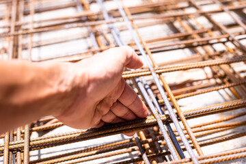 Selective focus to construction worker hand holding iron mesh (wire mesh) use for reinforce...