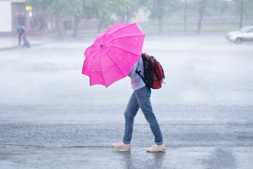 Storm, heavy rain in the city.People in the rain with an umbrella.