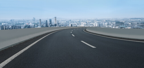 Fototapeta premium Asphalt pavement and urban building skyline