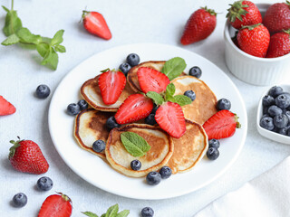 Pancakes with berries on the white background.