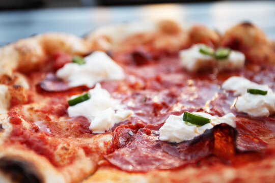 Italian thin crust pizza with prosciutto, jalapeno and buratta cheese