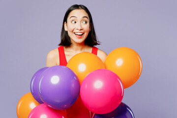 Fototapeta na wymiar Young excited woman of Asian ethnicity she wear casual clothes red tank shirt hold bunch of colorful air balloons look aside isolated on plain pastel light purple background studio. Lifestyle concept.