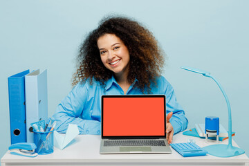 Young happy employee business woman in casual shirt sit work at white office desk with blank screen workspace area pc laptop look camera isolated on plain pastel light blue background studio portrait.