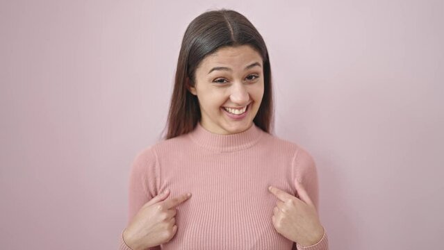 Young beautiful hispanic woman pointing herself saying no with fingers over isolated pink background