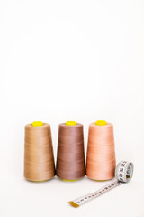 Colorful bobbin thread with measuring meter. Spool of sewing thread, isolated on white background. Colored yarns used by factories in the clothing industry. Threads wound on the spool. Colored reels