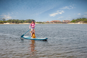 Pretty young girl and her Border Collie paddling on the lakes of Nouvelle-Aquitaine