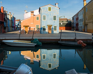Colourful houses with reflection in canal on summer day. Burano, Italy, Europe.