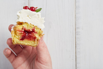 Berry cupcake in a cut. Woman holding a dessert in hand.