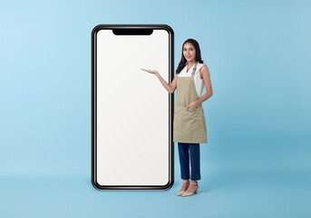 Entrepreneur asian woman showing big mobile cell phone with blank screen isolated on blue studio...