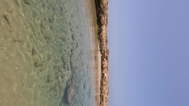 Experience the breathtaking beauty of a wild beach near Atlit, Israel. This stock video showcases the clear turquoise waters and tranquil atmosphere of the Mediterranean bay.
