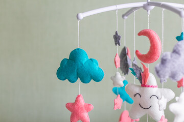 Cute mobile with clouds, stars and moon hanging on a crib in a children's room