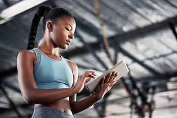 Black woman, typing or personal trainer with a tablet for fitness training, workout or sports exercise. Progress results, digital technology app or gym instructor planning a online coaching schedule
