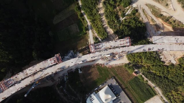 Highway bridge under construction. Aerial view of nes road. Freeway being built on a mountain terrain..