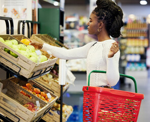 Black woman, supermarket and shopping for fruit, choice or discount for health, diet or nutrition in customer experience. Plastic basket, grocery store or mall for retail, sales or girl with decision