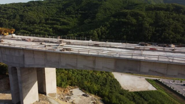Highway bridge under construction. Aerial view of nes road. Freeway being built on a mountain terrain..