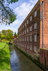 Exterior of restored cotton spinning and weaving mill in north of England with river