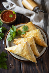 Asian food. Vegetarian samsa (samosas) with tomato sauce on a wooden table. Popular in Indonesia as Risoles Sayur.