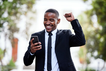 Black man, business and phone with celebration in street for winning, trading profit or bonus in city. African businessman, smartphone and winner on internet for esports, gambling or promotion at job