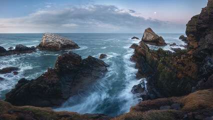 Amazing panorama of the sea cliffs on the northern Scottish coast and rough seas. Famous rock formation on the Moray Coast, Scottish Highlands, Scotland