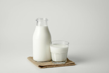 A glass and bottle of milk of milk on a white background