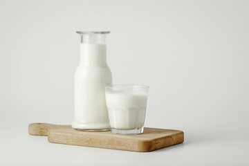 A glass and bottle of milk of milk on a white background