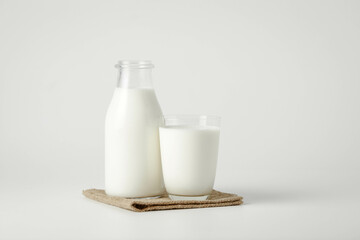 A glass and bottle of milk of milk on a white background