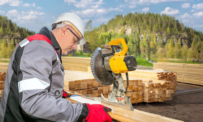 Man works at sawmill. Worker near stationary circular saw. Woodworking process. Man among boards....