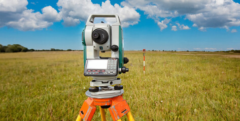 Cartography. Theodolite on the background of a topographic map. Geodesic and cartographic equipment. Study of the area. Mapping. Work of the cartographer. Topography and cartography.
