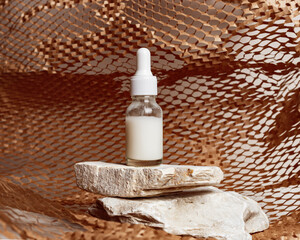 Glass dropper bottle with extract coconut or serum on natural stones, with paper geometric grid decor background. Natural Organic Spa Cosmetic trendy concept, cosmetic product mock up.