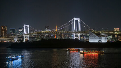 Fototapeta na wymiar Rainbow bridge and ships with Tokyo tower at night, Japan