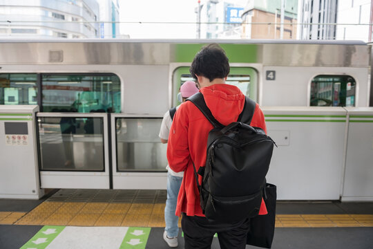 Japanese people stand on line for JR Yamanote train at station