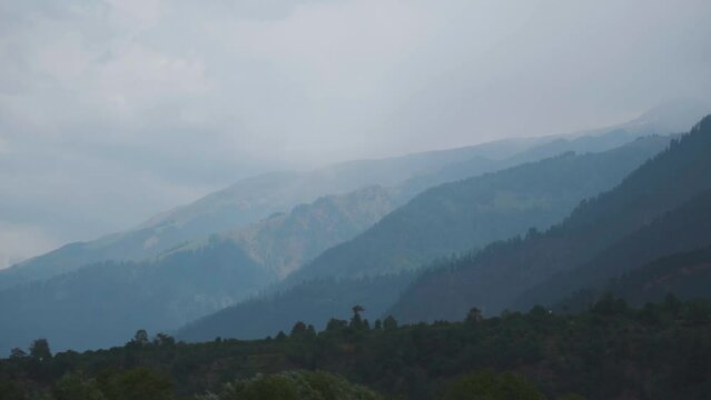 Himalayan mountain range of Kullu valley during morning as seen from the top of a mountain peak at Manali in Himachal Pradesh, India. Stormy monsoon mountains landscape.