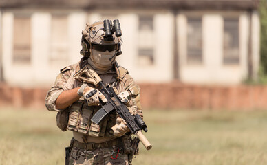 Special forces soldier in camouflage with a pair of weapons that are full of modern technology and...