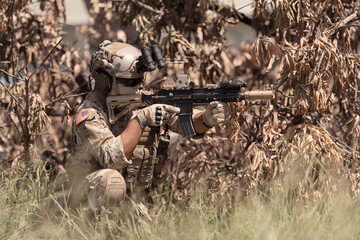 Special forces soldier in camouflage with a pair of weapons that are full of modern technology and...