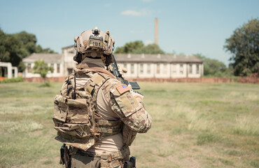 Special forces soldier in camouflage with a pair of weapons that are full of modern technology and...