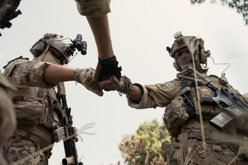 Special forces soldier in camouflage, fist bump and send energy to each other before performing an...