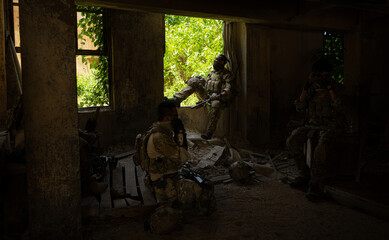 Special forces soldier in camouflage, Take refuge in an abandoned building before starting a new patrol operation.