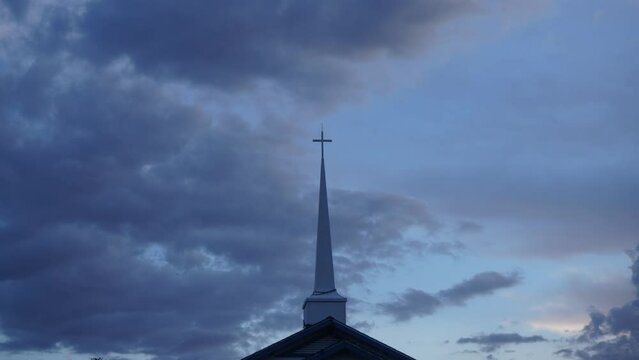 Time lapse of a church steeple with clouds in the background
